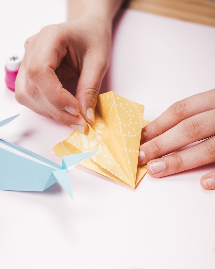 Χέρια διπλώνουν και δημιουργούν papercraft