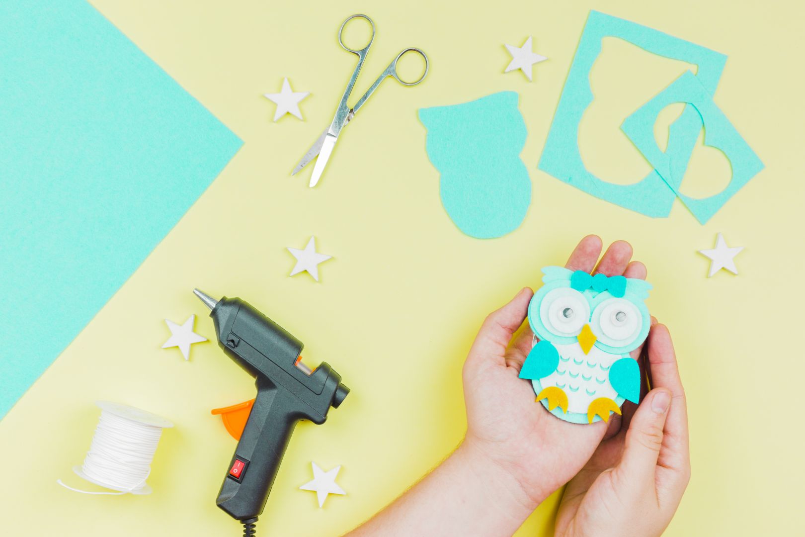 Η τέχνη του papercraft σε δράση Χέρια δουλεύουν πάνω σε ένα πολύχρωμο χειροποίητο έργο από χαρτί, γεμάτο λεπτομέρειες και υφές.